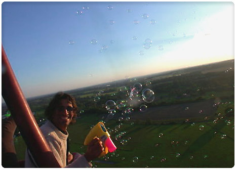 Using a bubble gun from the hot air balloon basket, during the flight